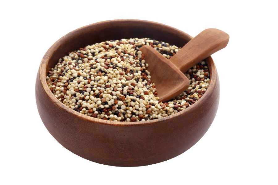 fresh mixed quinoa in a bowl with a wooden spoon